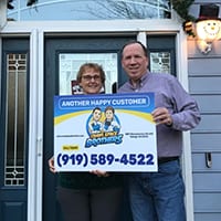 Customers holding a Crawl Space Brothers customer sign