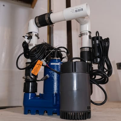 Close-up of installed sump pump equipment and pipes.