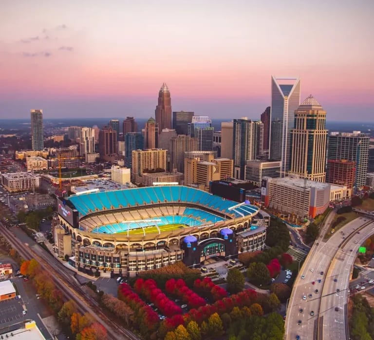 Aerial view of the Charlotte skyline and stadium at sunset