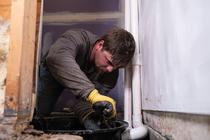 an Anchored Walls employee installing a sump pump in Des Moines