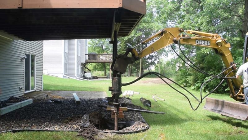 Helical install being done underneath a deck