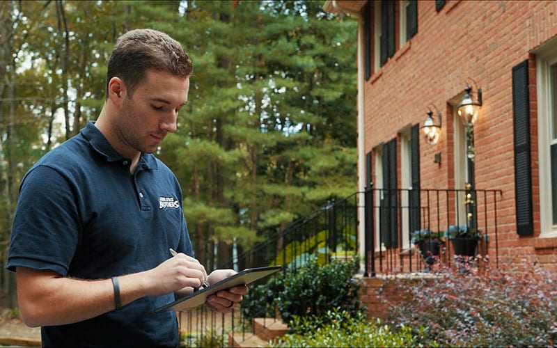 An inspector documents findings outside a home