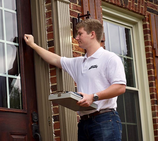 A Crawl Space Brothers specialist discusses a written plan with a homeowner