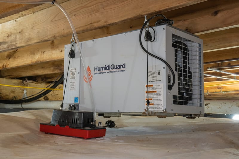 A technician fitting liner material inside a crawl space