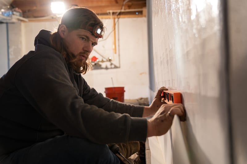 A specialist working on basement waterproofing