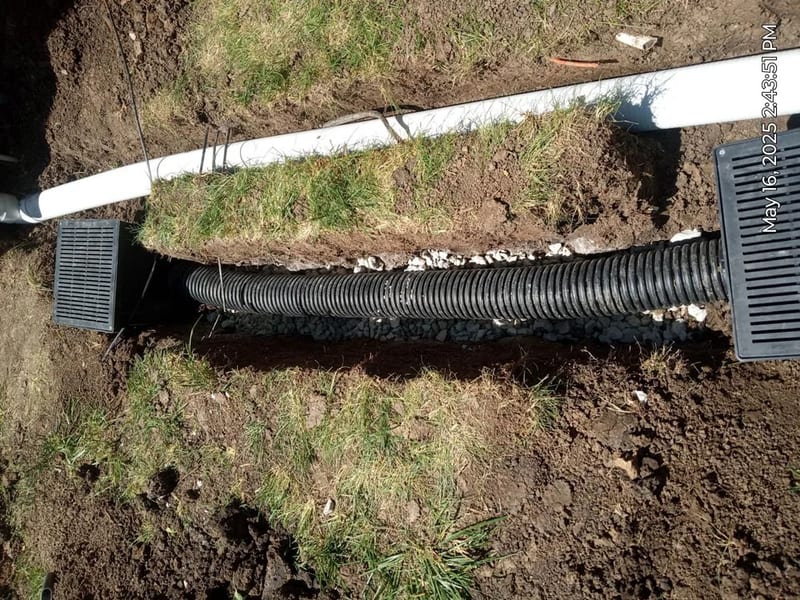 Exterior drainage pipe surrounded by gravel during installation