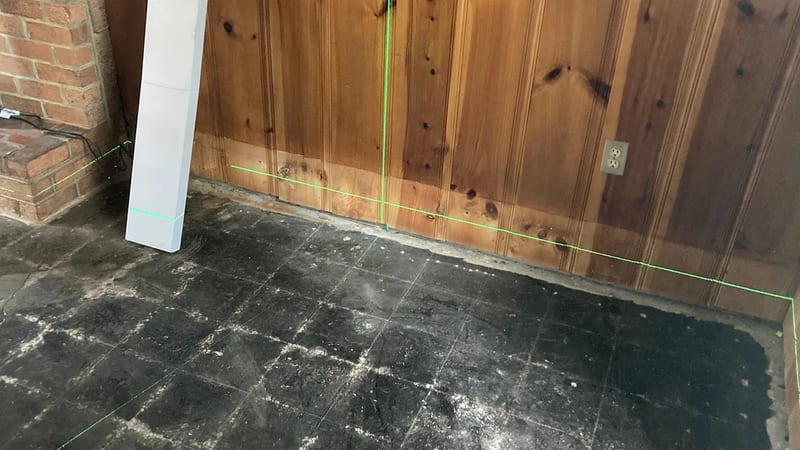 A laser level checking a floor and wall