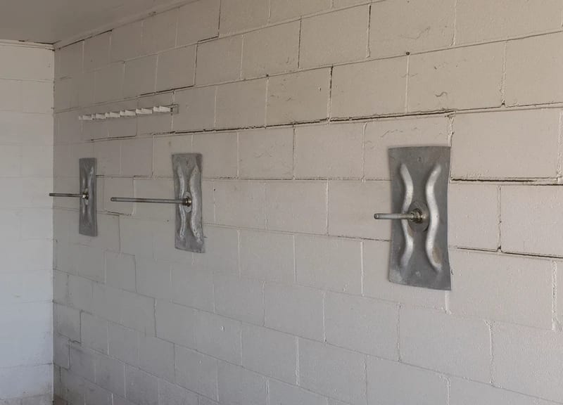 Wall anchor plates installed on a basement wall