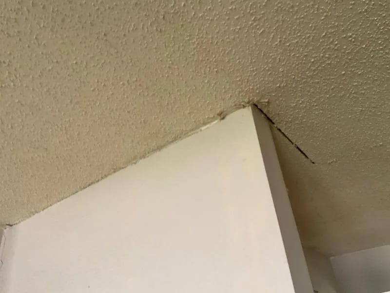 A crack where a ceiling meets an interior wall